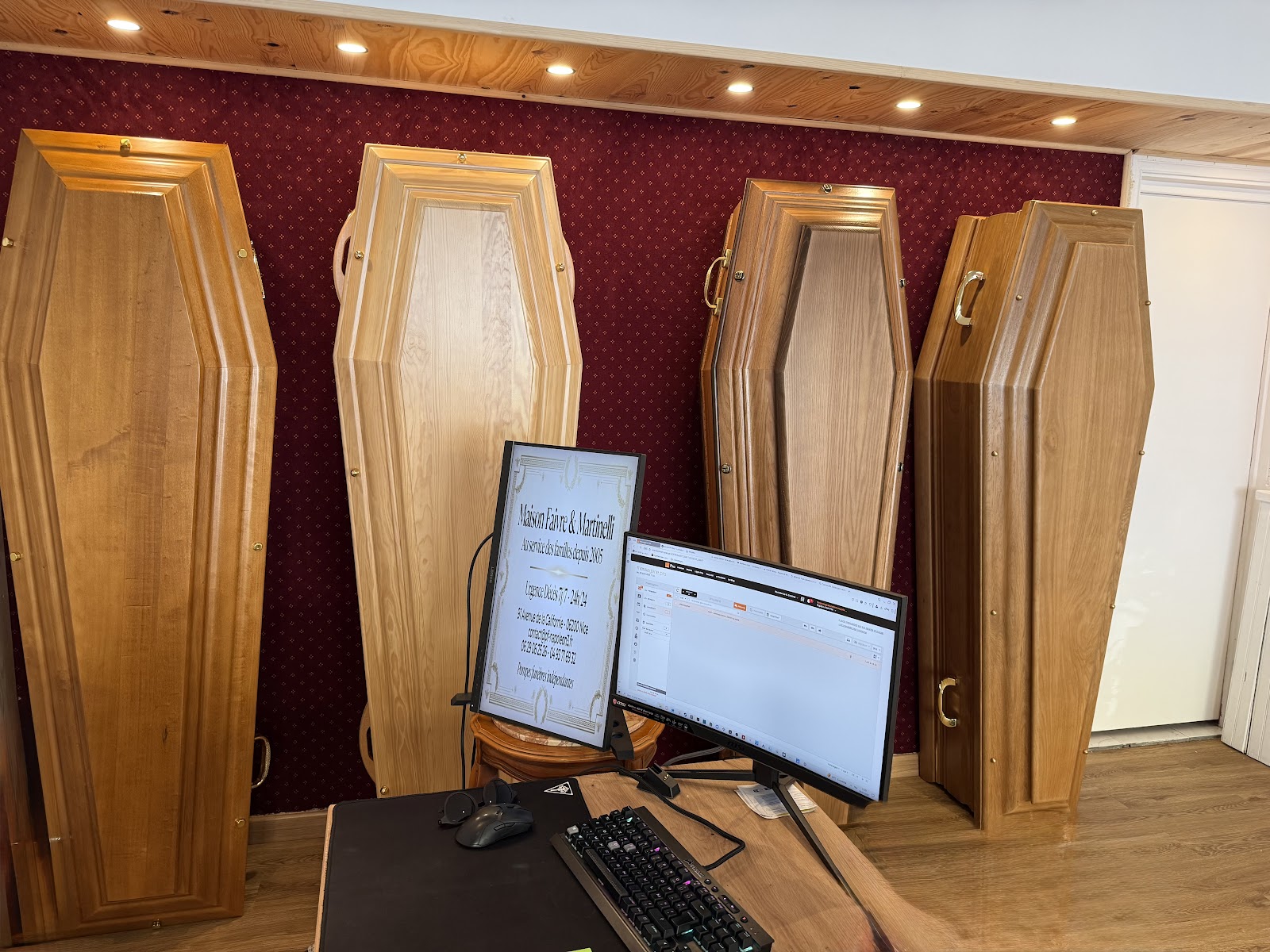 Salon d'exposition avec cercueils en bois et bureaux d'accueil